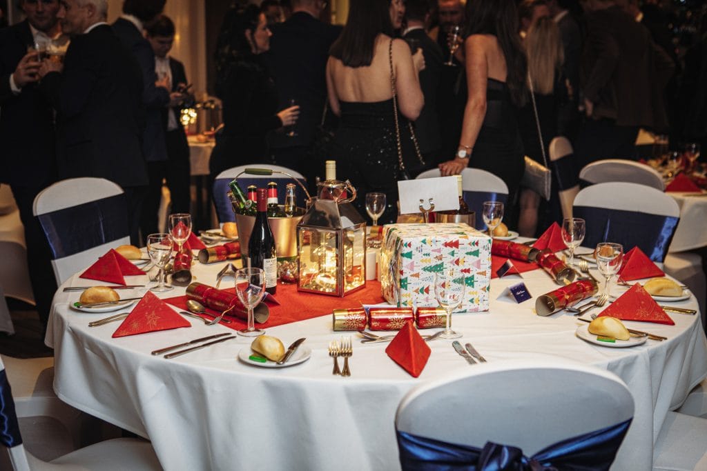 table decorated with red christmas decorations at a christmas party in swanley