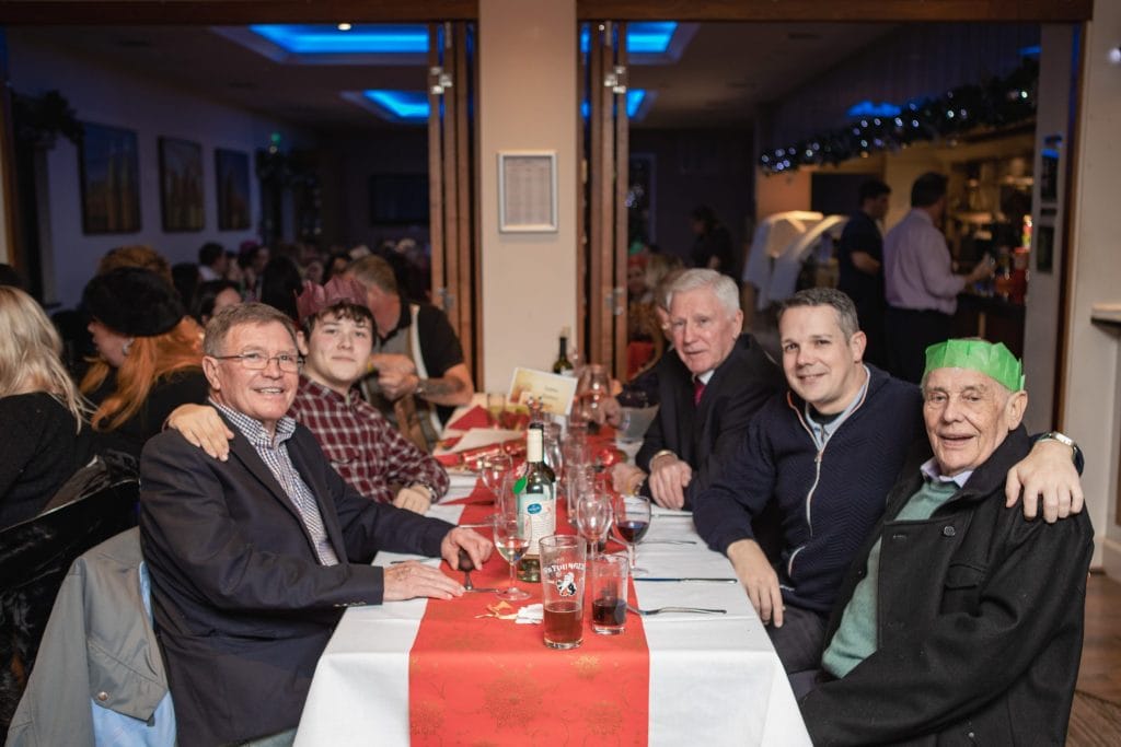Group of people sat at table at christmas party in dartford