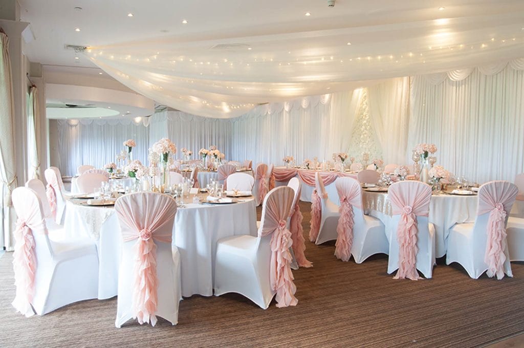Wedding reception in kent with blush pink theme and wall draping