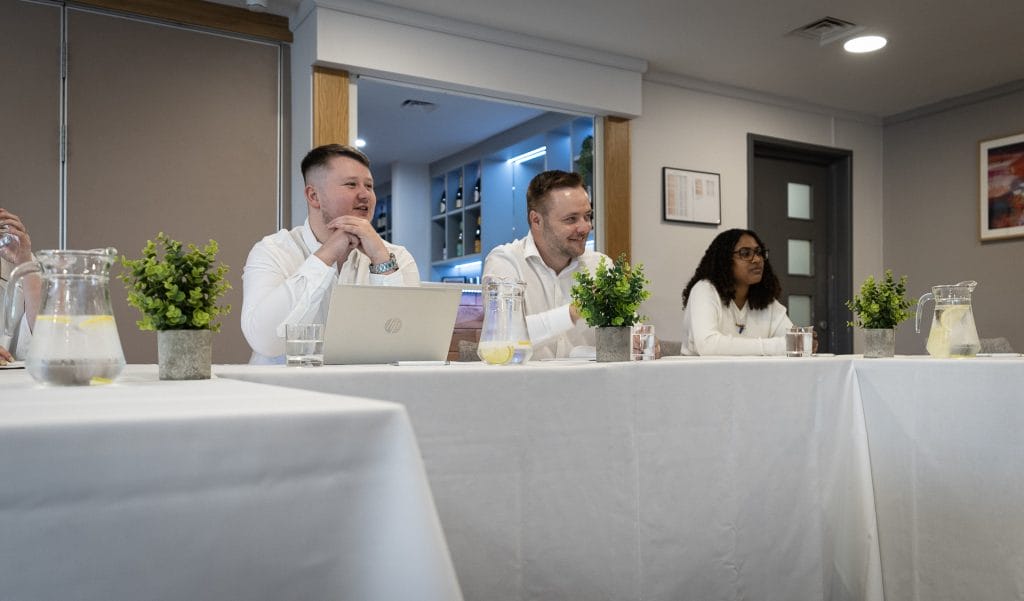 Three meeting delegates sitting at table in meeting at Birchwood Park