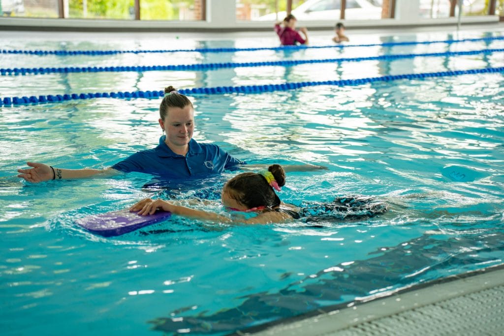 swimming lessons with teacher helping child swim in dartford