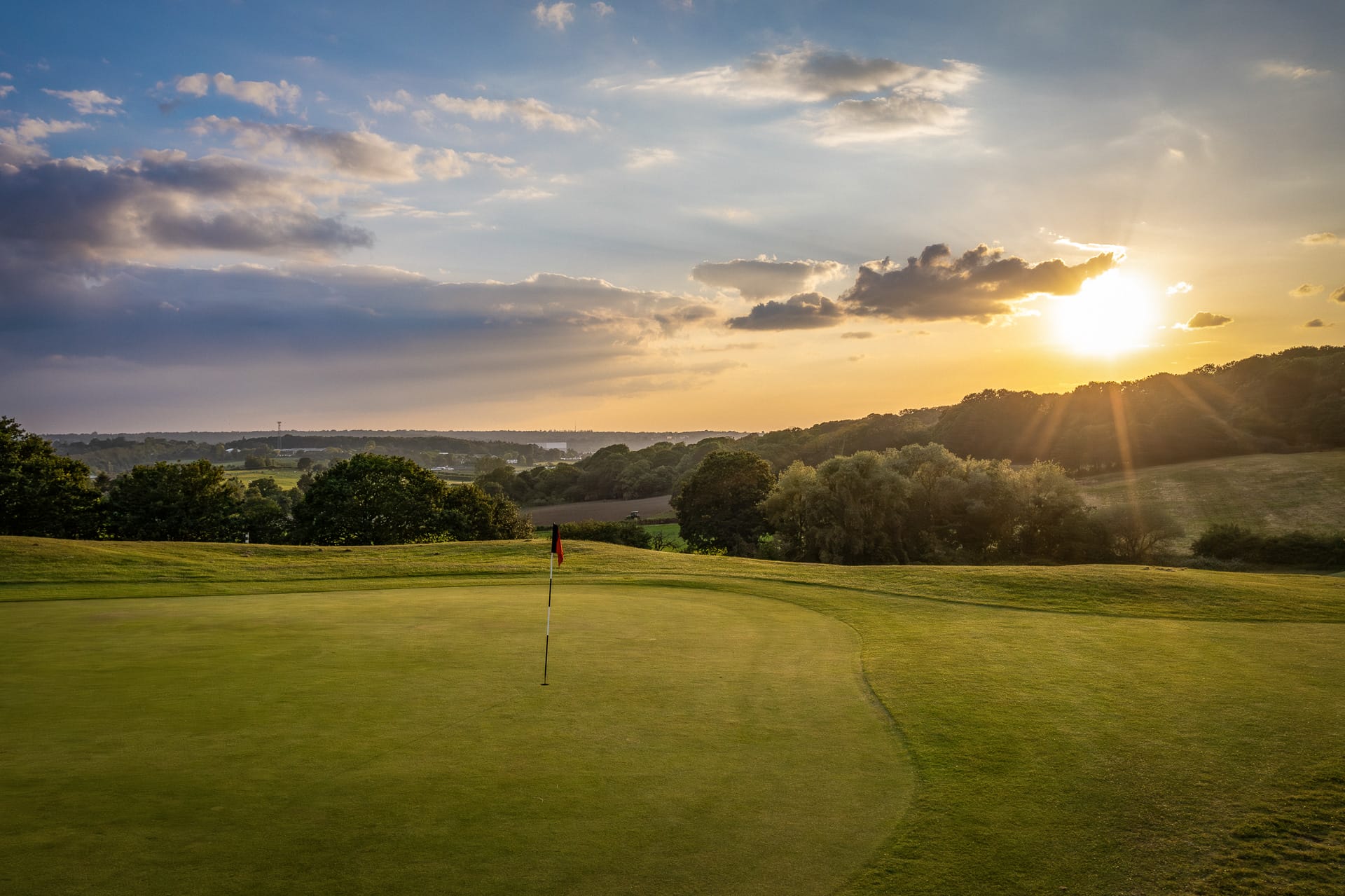 sun setting over golf course in kent