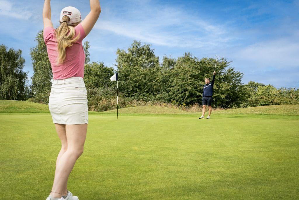 Woman celebrating a golf shot on the green