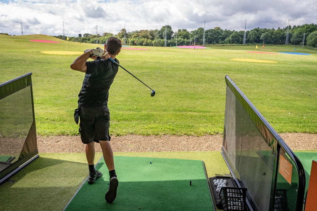 golfer hitting ball out of a trackman driving range in dartford