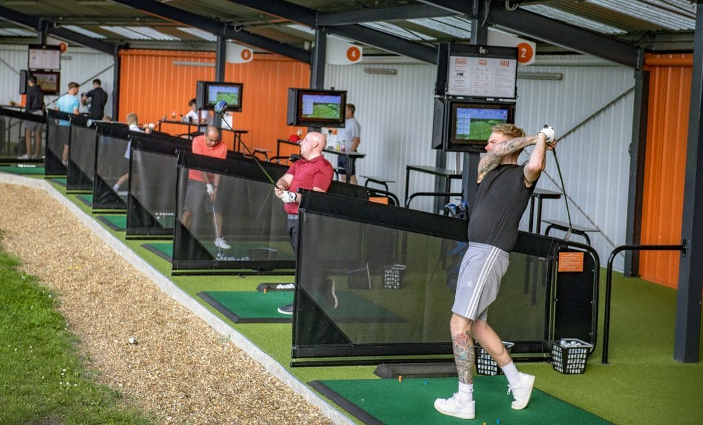 gofers hitting balls out of trackman driving range in dartford
