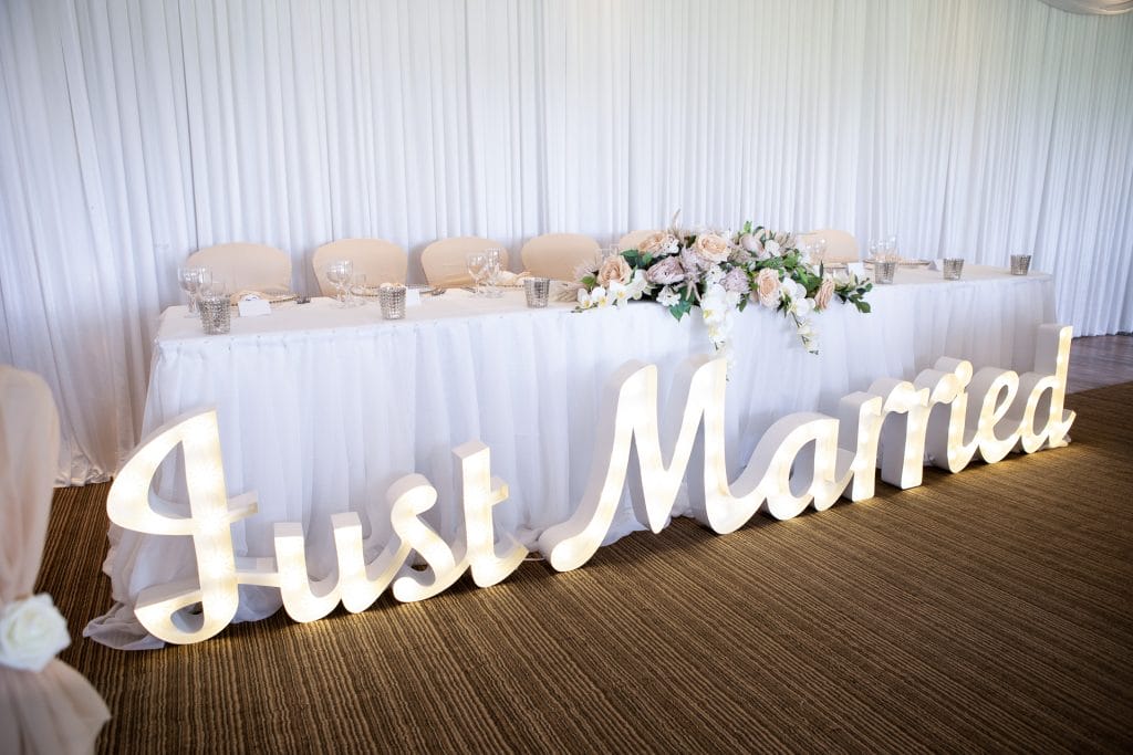 Wedding reception decorations and top table with wall draping and centre pieces