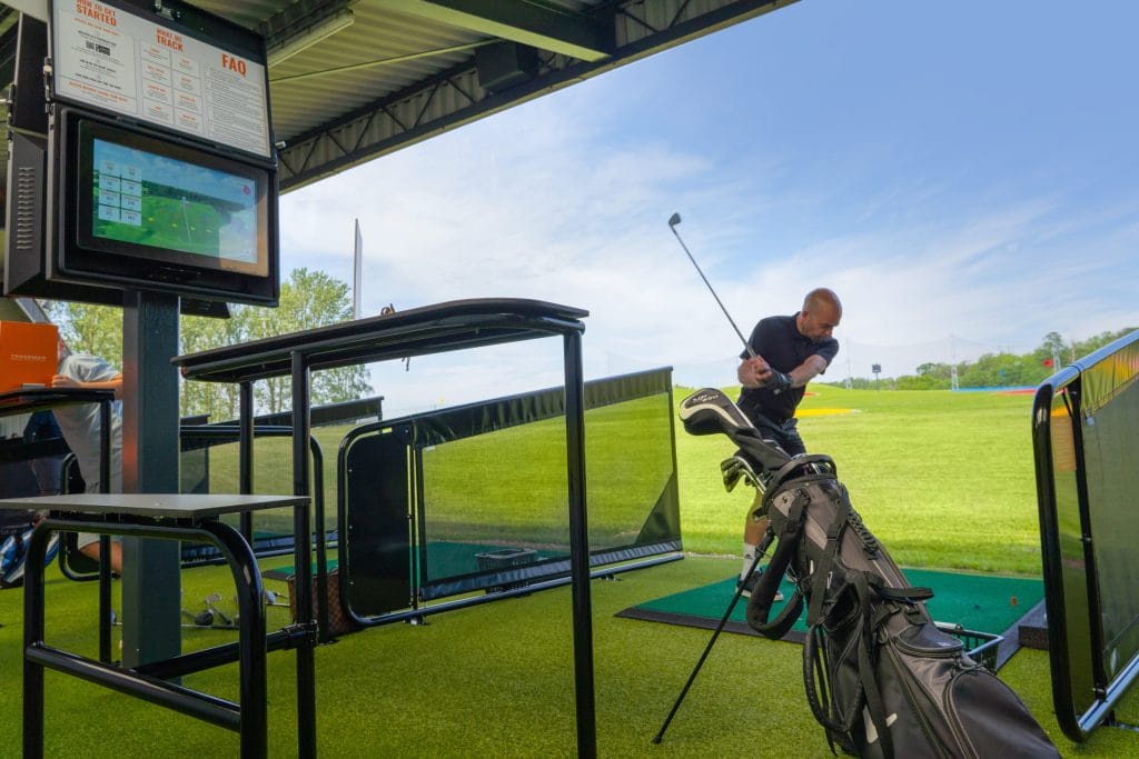 golfer about to hit a ball out of the driving range in kent