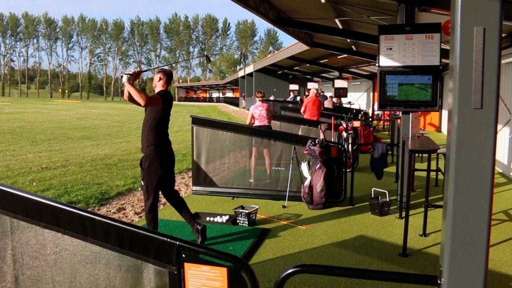 Driving range walkthrough showing man hitting balls and the trackman technology