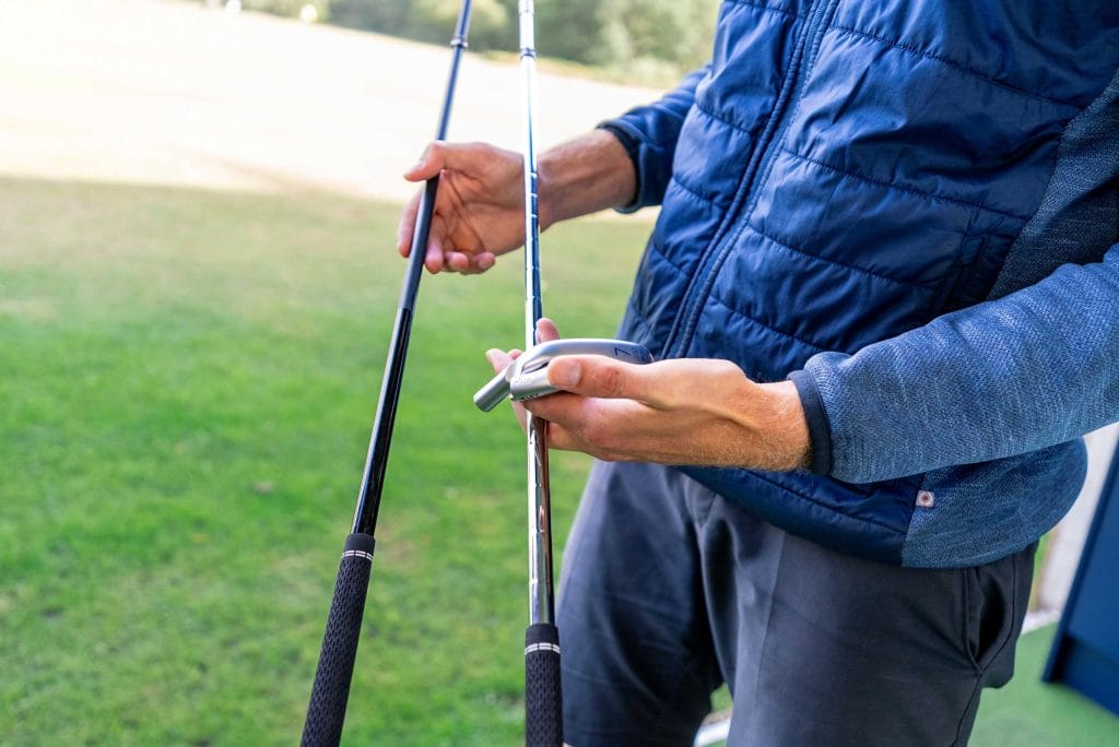 Man holding two clubs for a custom fit session in dartford