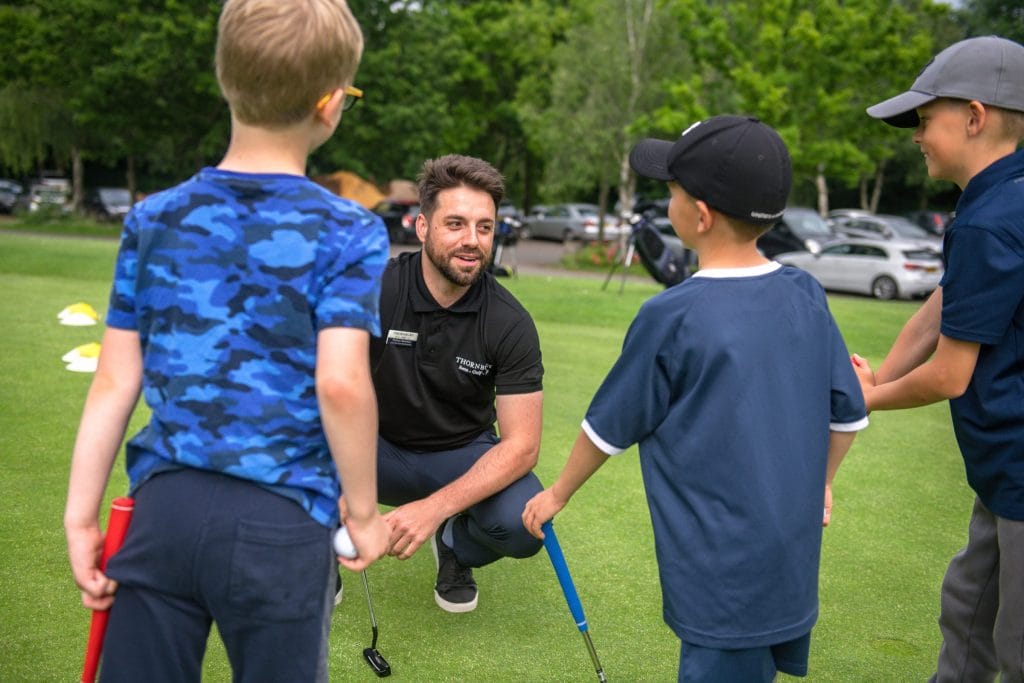 Three junior golfers having a golf lesson with the PGA qualified coach in kent