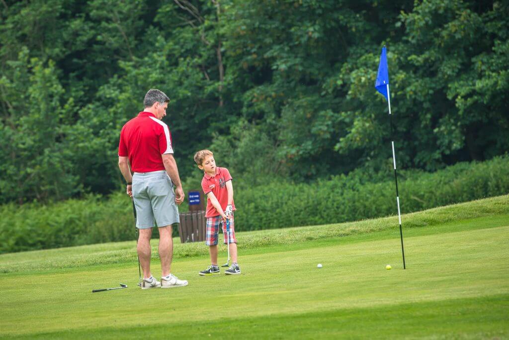 A junior is having a golf lesson on the golf course at Birchwood Park golf and country club