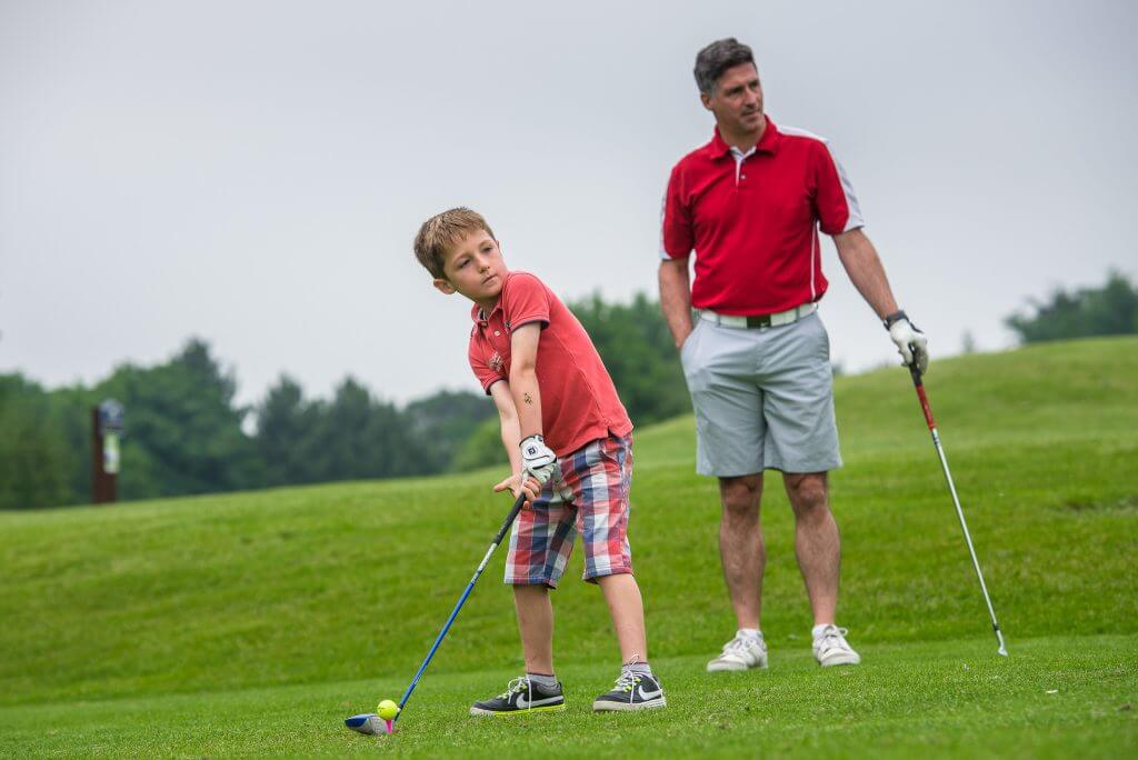 Junior is having a golf lesson from a PGA qualified coach on the golf course